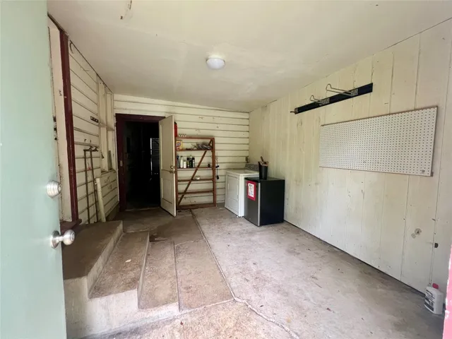 a view of an empty room with closet and a window