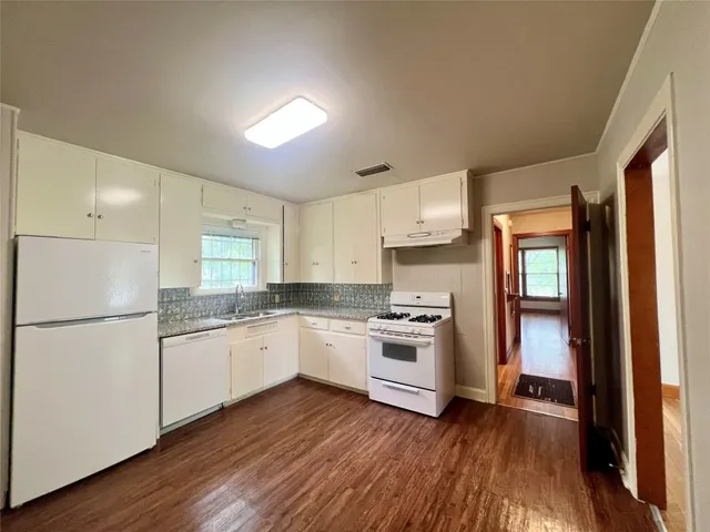 a kitchen with granite countertop appliances a sink and a refrigerator