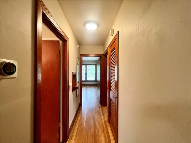 a view of a hallway with wooden floor and staircase