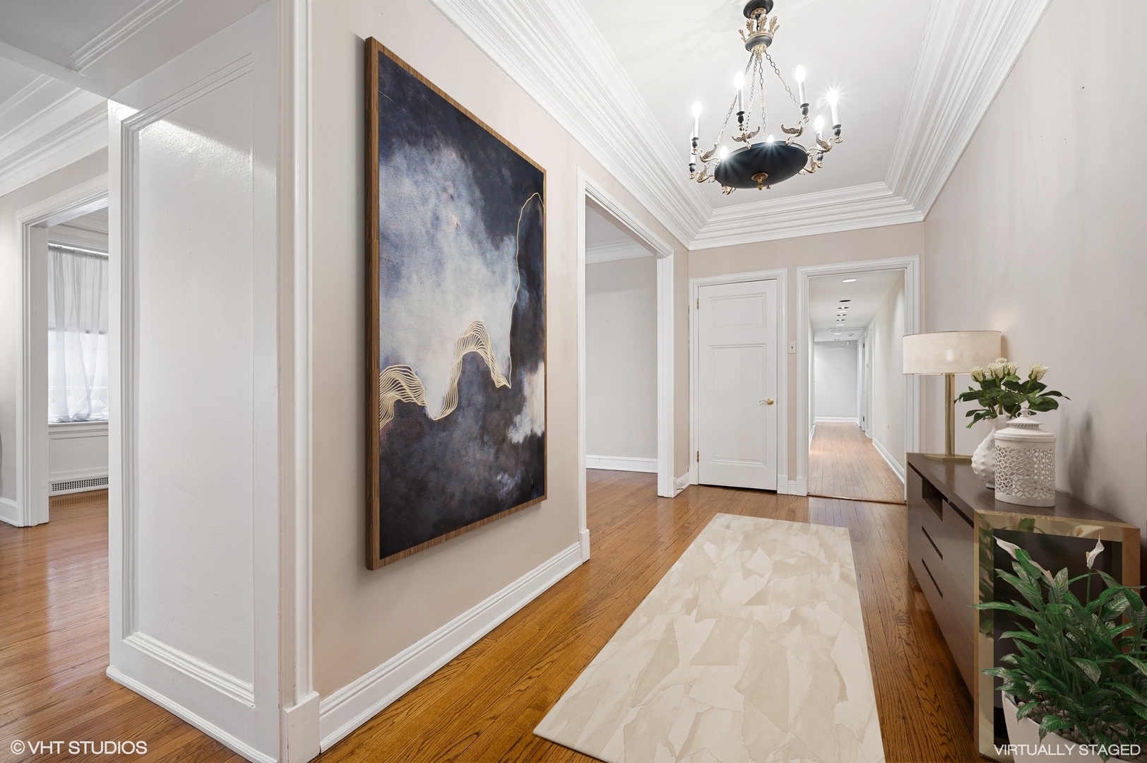 237 East Delaware Place, Unit 2A Chicago, IL 60611 - Photo 2 of 19 a view of a hallway that has a bed and a chandelier