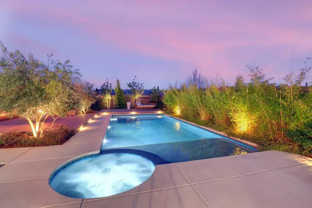 a view of a swimming pool with a yard and mountain in the back
