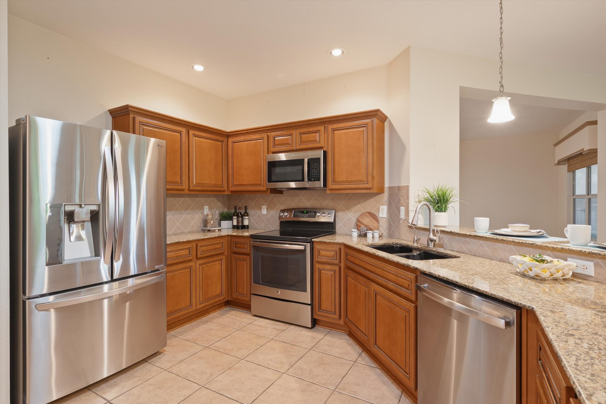 126 Trail Rider Way Georgetown, TX 78633 - Photo 13 of 30 a kitchen with stainless steel appliances granite countertop a refrigerator stove a sink and a microwave