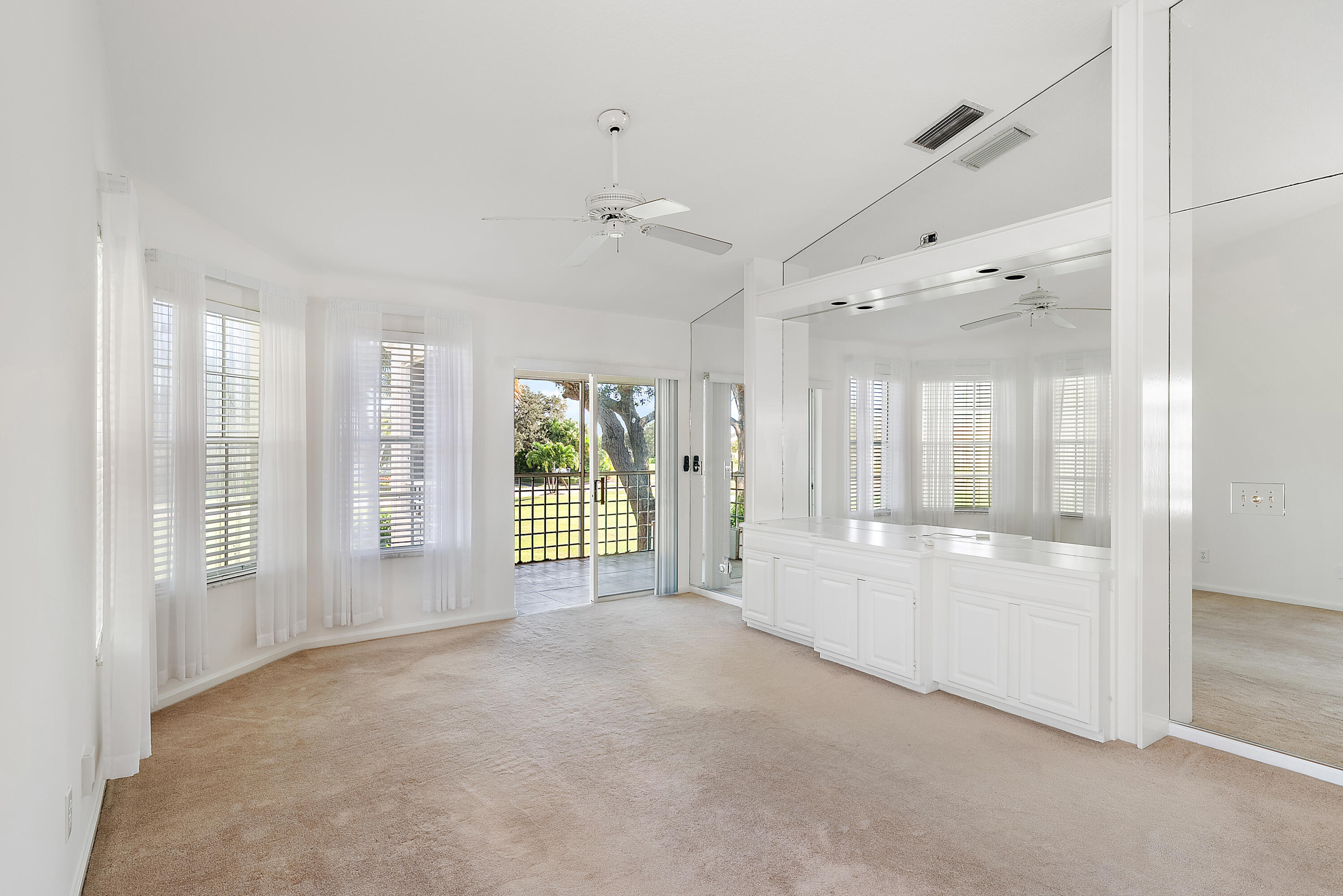 802 Muirfield Court, Unit 802A Jupiter, FL 33458 - Photo 2 of 25 a large white room with windows and chandelier