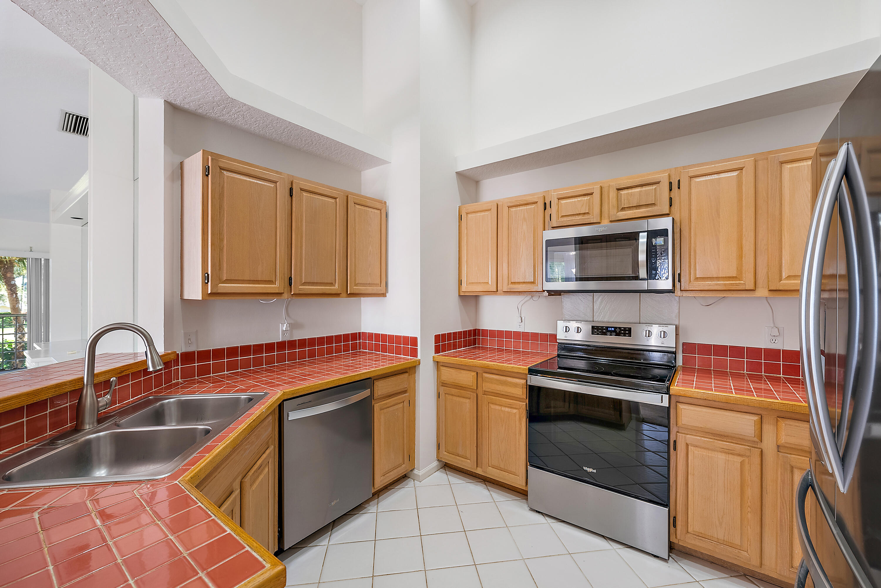 802 Muirfield Court, Unit 802A Jupiter, FL 33458 - Photo 7 of 25 a kitchen with granite countertop a sink stove and microwave