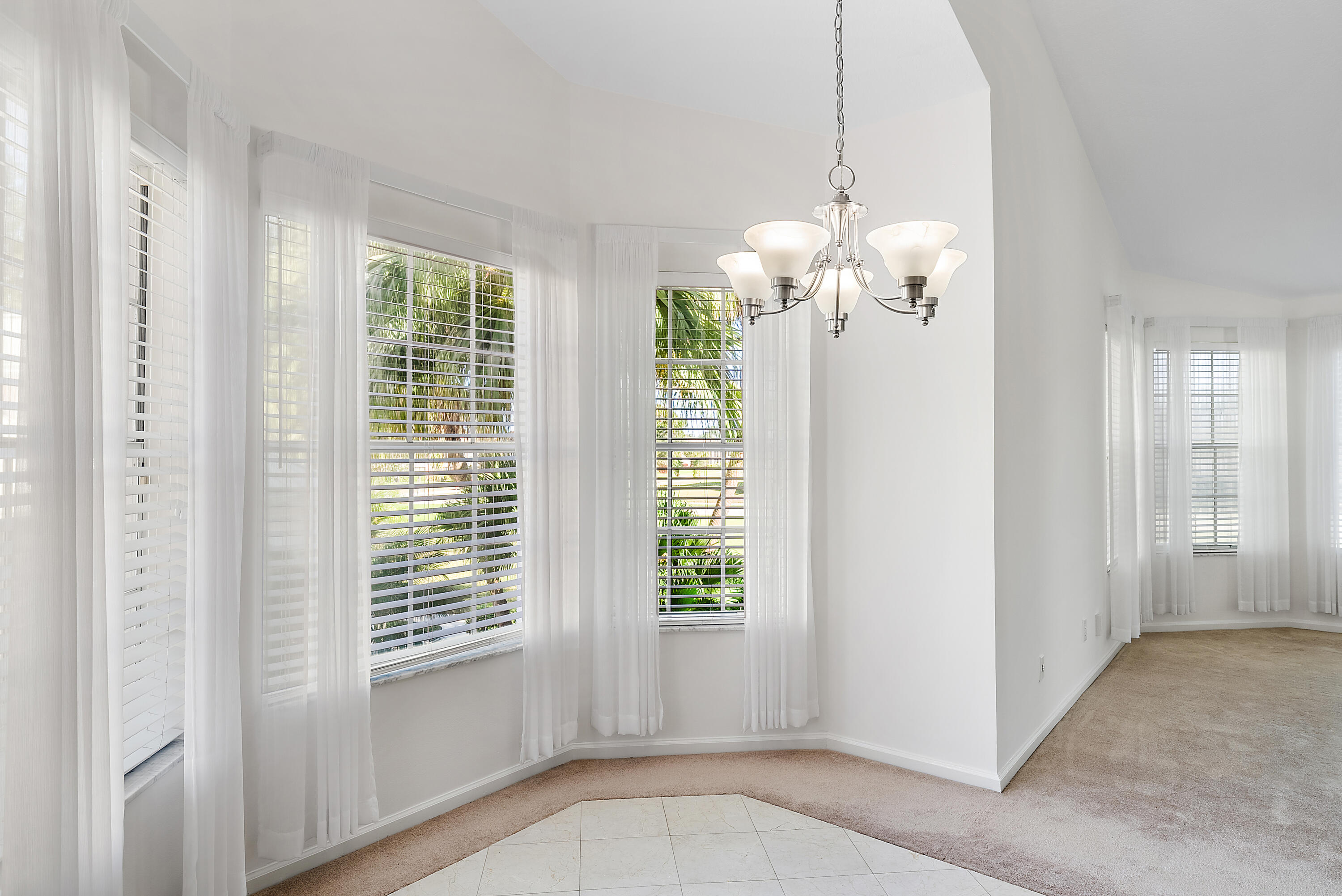 802 Muirfield Court, Unit 802A Jupiter, FL 33458 - Photo 8 of 25 a view of a livingroom with a chandelier fan and windows