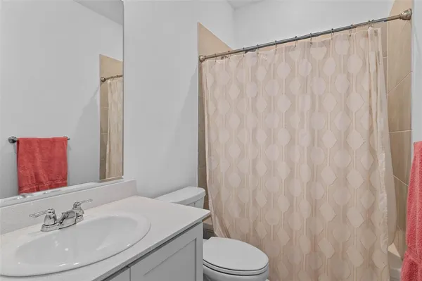 a bathroom with a sink a toilet and shower curtain