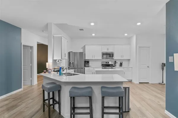a kitchen with a dining table chairs refrigerator and cabinets