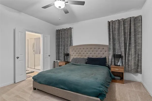 a bedroom with a large bed and a chandelier