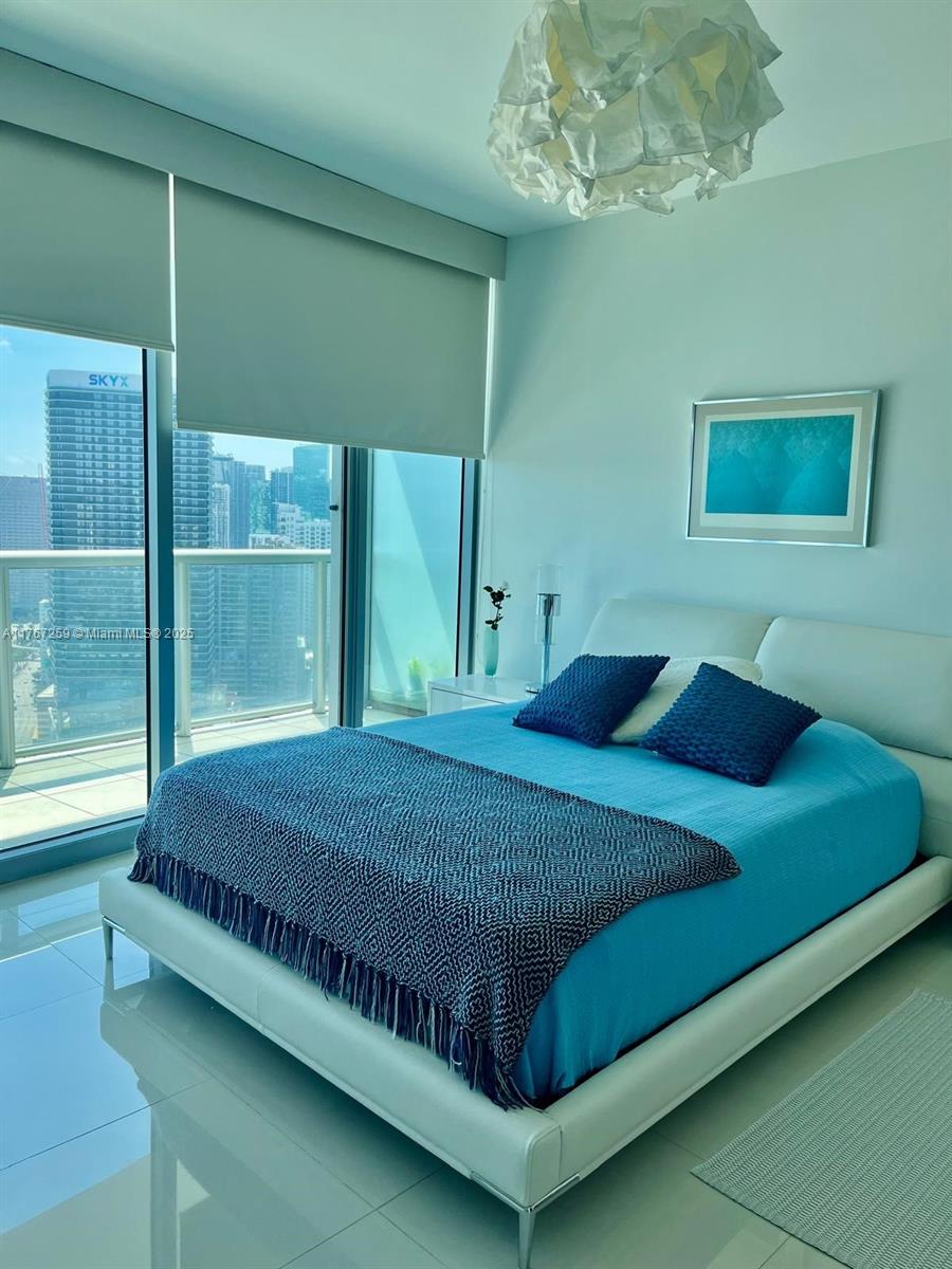 888 Biscayne Boulevard, Unit 4306 Miami, FL 33132 - Photo 28 of 70 a bed sitting in a bedroom next to a window