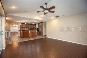 a view of a living room a ceiling fan and kitchen view