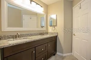 a bathroom with a granite countertop sink and a mirror