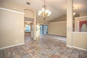 a view of a hallway with chandelier and glass door