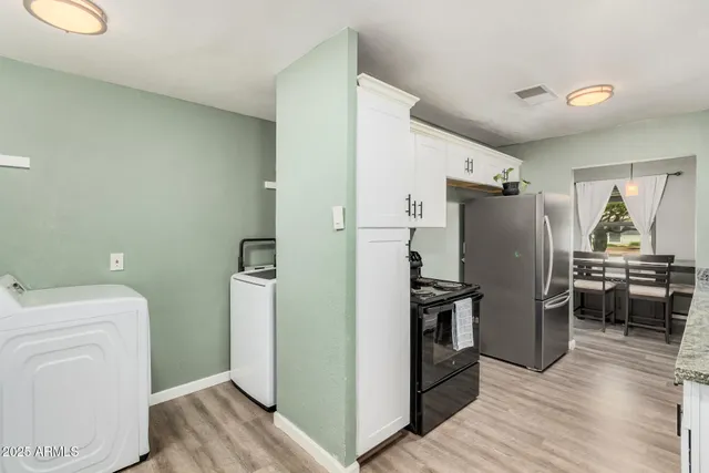 a kitchen with a refrigerator and a stove top oven