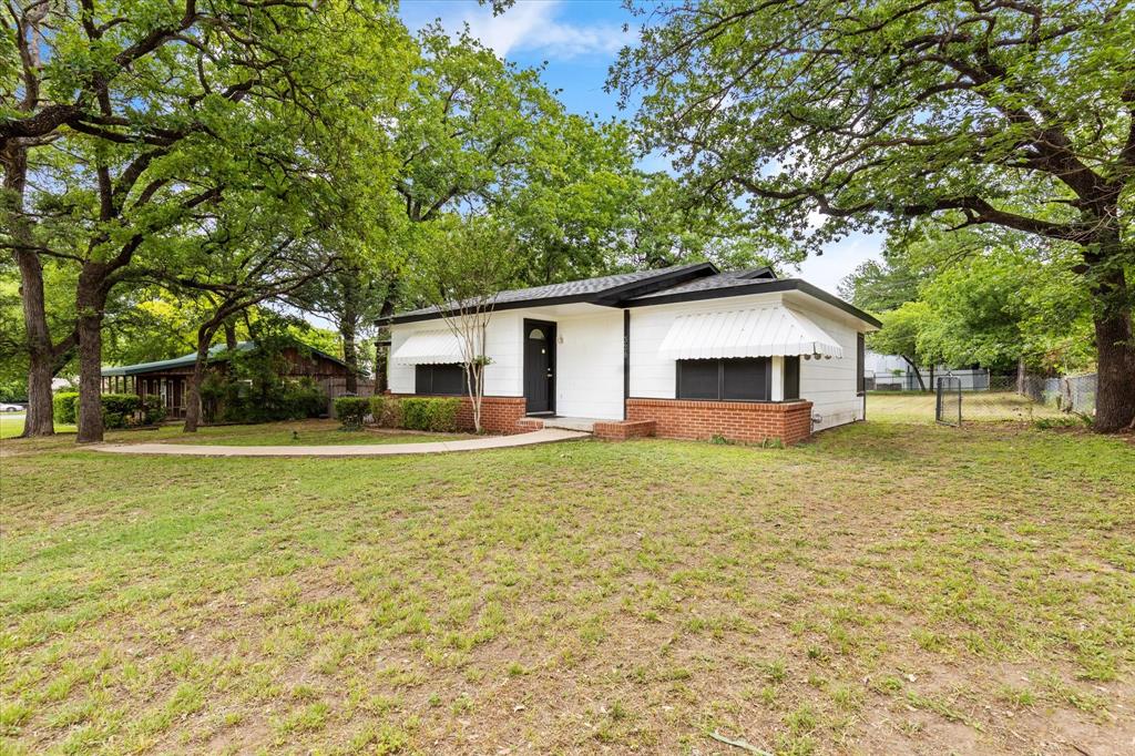 a view of a house with backyard and trees