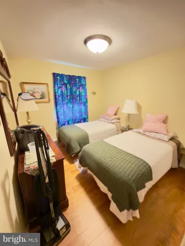 a spacious bedroom with two beds and a painting on the wall