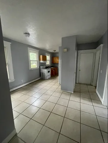 a view of empty room with windows and cabinet