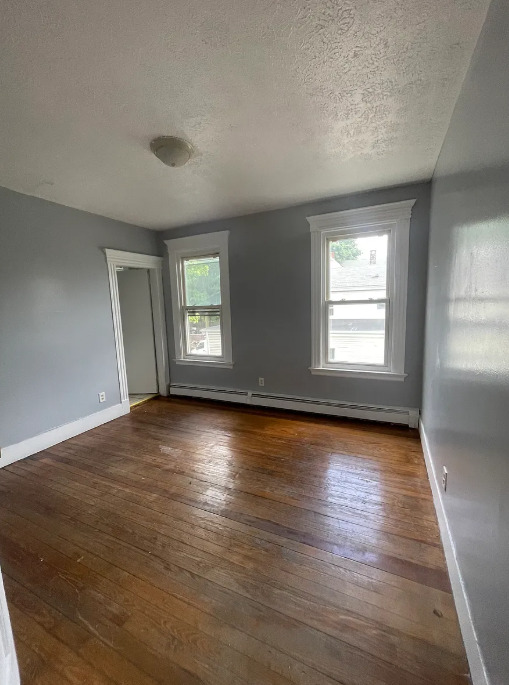 414 Dixwell Avenue, Unit 2 New Haven, CT 06511 - Photo 5 of 8 an empty room with wooden floor and windows