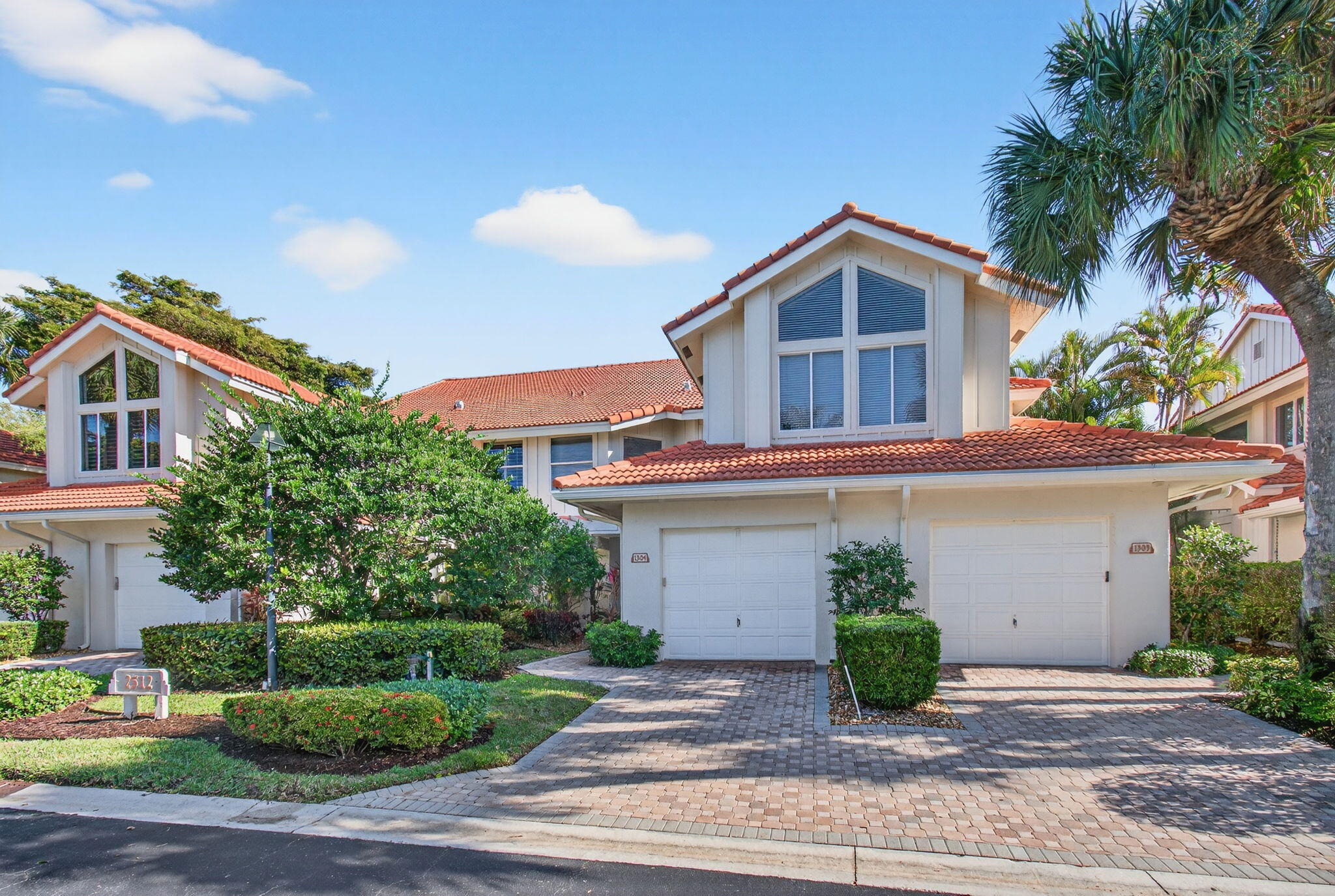 a front view of a house with a yard and potted plants