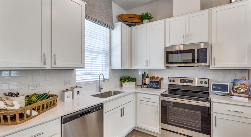 3950 Dechman Drive, Unit 2015 Grand Prairie, TX 75052 - Photo 24 of 27 a kitchen with stainless steel appliances granite countertop a sink a stove and a microwave
