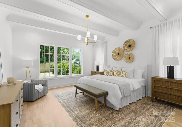 a bedroom with a bed dresser and a large window