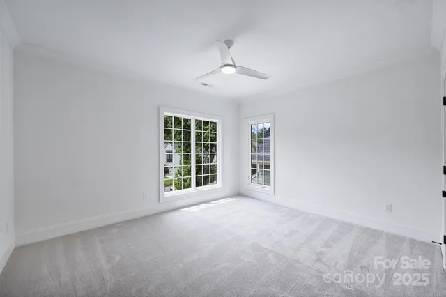 an empty room with windows and chandelier