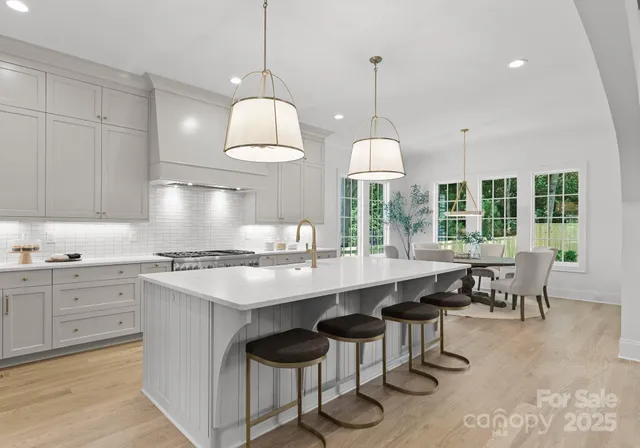 a kitchen with cabinets a sink dining table and chairs