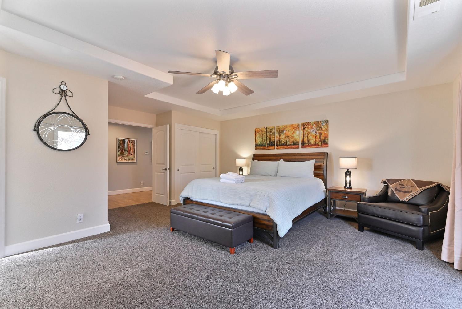 333 Oak Tree Circle Murphys, CA 95247 - Photo 29 of 88 a spacious bedroom with a bed and a chandelier