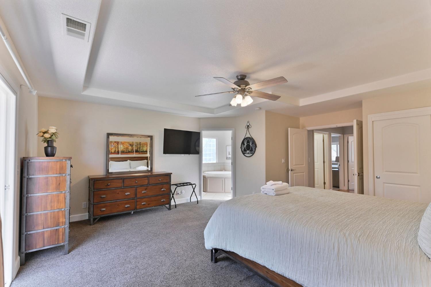 333 Oak Tree Circle Murphys, CA 95247 - Photo 30 of 88 a bedroom with a bed and a chandelier