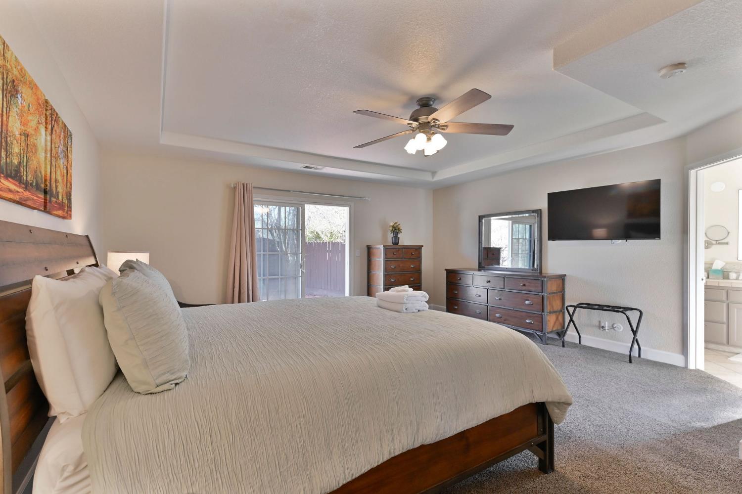 333 Oak Tree Circle Murphys, CA 95247 - Photo 31 of 88 a bedroom with a large bed a flat tv screen and a dresser