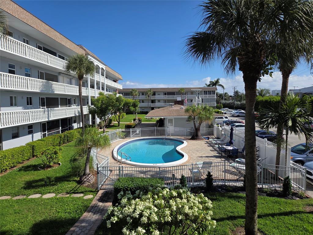 1971 Southeast 5th Court, Unit 101E Pompano Beach, FL 33060 - Photo 12 of 12 a table and chairs in front of the house