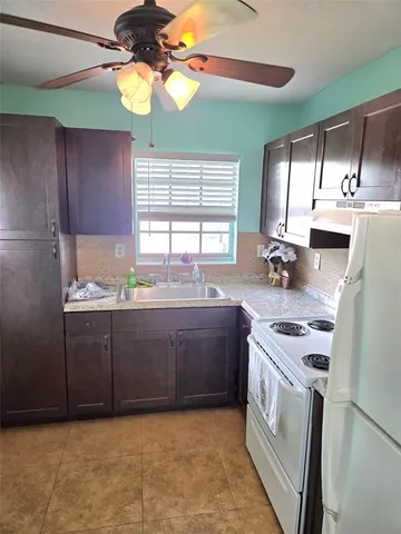a kitchen with kitchen island granite countertop a sink cabinets and window