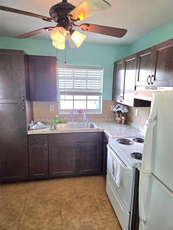 1971 Southeast 5th Court, Unit 101E Pompano Beach, FL 33060 - Photo 2 of 12 a kitchen with kitchen island granite countertop a sink cabinets and window