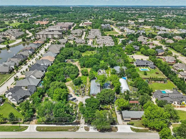 an aerial view of residential houses with outdoor space and trees