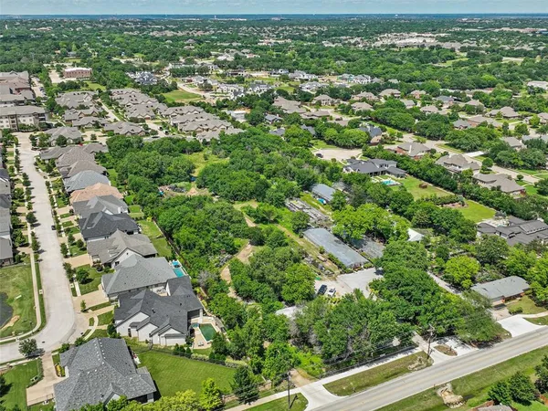 an aerial view of residential house with outdoor space and trees all around