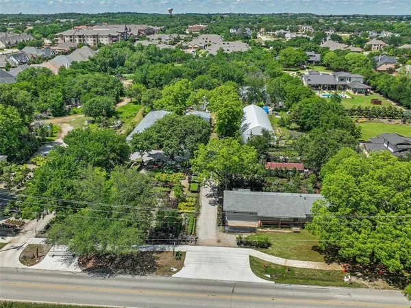 an aerial view of residential house with outdoor space and trees all around