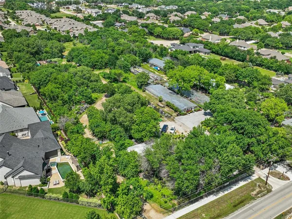 an aerial view of residential house with outdoor space and trees all around