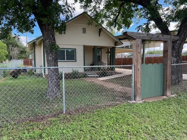 a view of a house with a yard and large tree