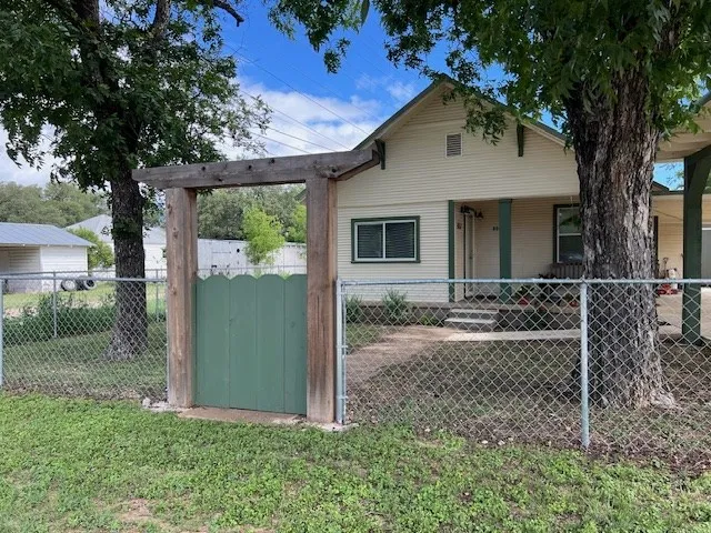 a view of a house with backyard and a tree