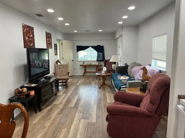 a living room with furniture and wooden floor