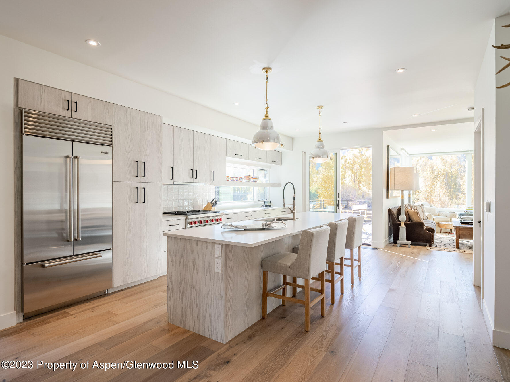 a kitchen with stainless steel appliances a stove a sink a center island and a wooden floor