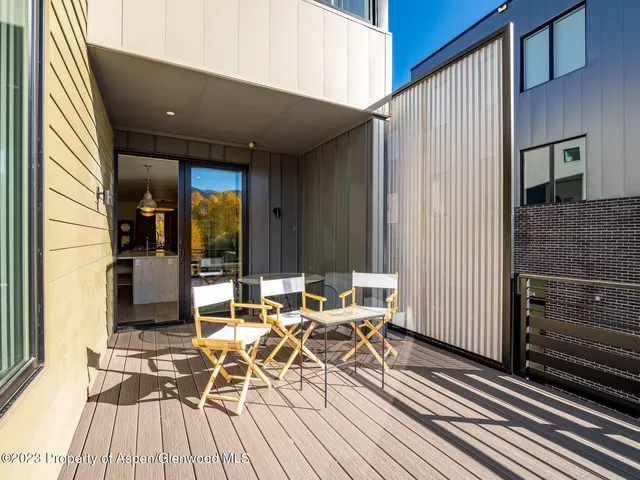 a view of a patio with table and chairs with wooden floor and barbeque oven