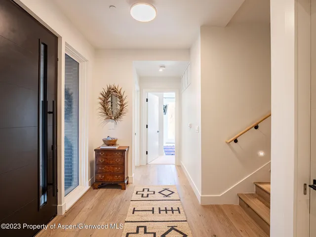 a view of a hallway with wooden floor and furniture