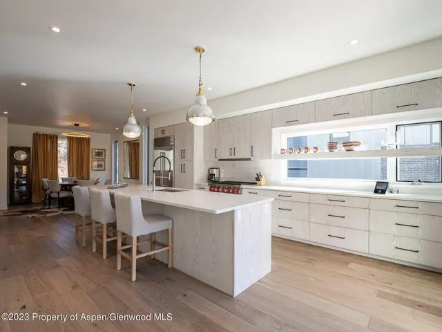 a large white kitchen with lots of white furniture