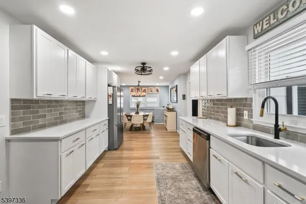 a large kitchen with stainless steel appliances granite countertop a sink and cabinets