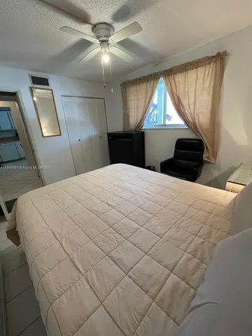 a bedroom with a bed and a flat tv screen on dresser