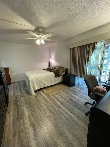 a bedroom with bed window and a ceiling fan