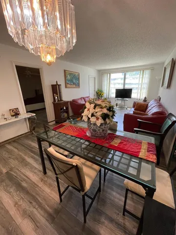 a living room with furniture a chandelier and a flat screen tv