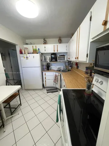 a kitchen with a sink a stove and cabinets