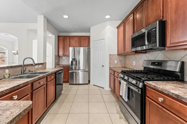 a kitchen with stainless steel appliances granite countertop a stove a sink and a microwave