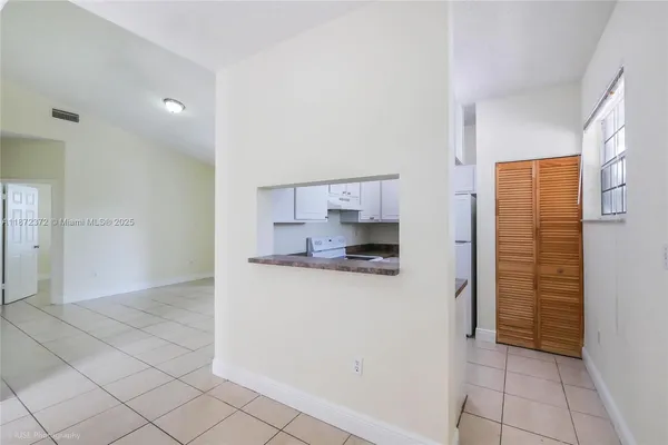 a view of kitchen with refrigerator and window
